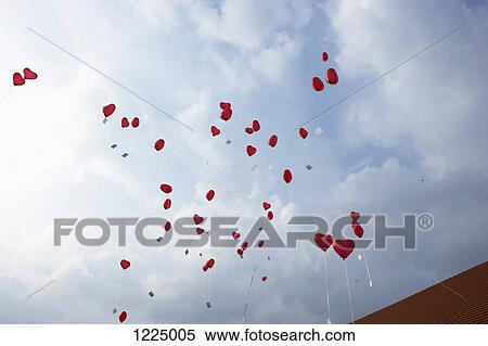 Stock Photography - Many red heart shaped helium balloons floating up. Fotosearch
