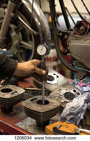 Picture - Mechanic checking cylinder bores with a dial bore gauge, . Fotosearch