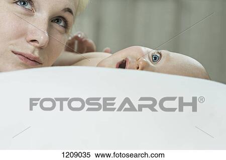 Stock Photography - Mother and son on bed looking up. Fotosearch