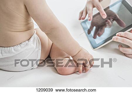Stock Photo - Mother showing son a digital tablet. Fotosearch