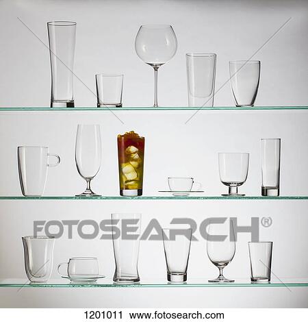 Stock Image - One glass filled with bubble tea placed amongst a collection of empty drinking glasses . Fotosearch