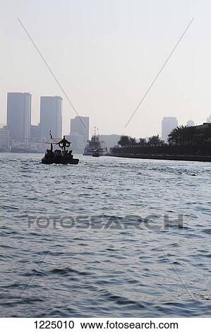 Stock Image - People on water taxi along Dubai creek, Dubai, United Arab Emirates. Fotosearch