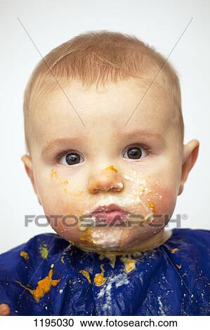 Stock Image - Portrait of a baby boy with food on his face. Fotosearch