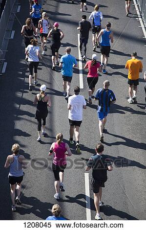 Stock Photography - Rear view of people running in a marathon. Fotosearch