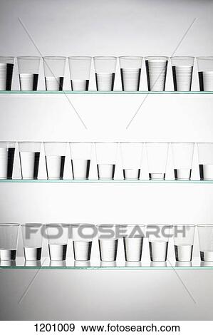 Rows of glasses filled with varying amounts of water View Large Photo Image Stock Photo - Rows of glasses filled with varying amounts of water. Fotosearch