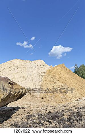 Sand mounds on construction site with scoop in the foreground View Large Photo Image Stock Image - Sand mounds on construction site with scoop in the foreground. Fotosearch