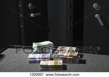 Stacks of large billed Euro banknotes on a table outside of a vault View Large Photo Image Stock Photo - Stacks of large billed Euro banknotes on a table outside of a vault. Fotosearch