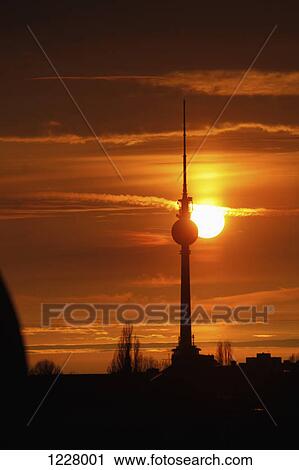 The Alexanderplatz television tower silhouetted against a beautiful sky with the sun setting View Large Photo Image Stock Image - The Alexanderplatz television tower silhouetted against a beautiful sky with the sun setting. Fotosearch