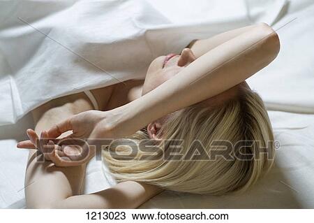 The sun shining on a woman lying down, arm resting on forehead View Large Photo Image Stock Image - The sun shining on a woman lying down, arm resting on forehead. Fotosearch