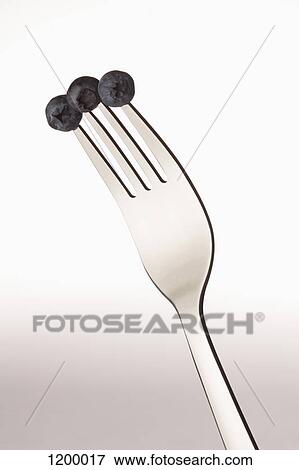 Three blueberries on a fork View Large Photo Image Stock Photo - Three blueberries on a fork. Fotosearch