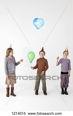 Three kids wearing party hats and holding balloons View Large Photo Image Stock Photography - Three kids wearing party hats and holding balloons. Fotosearch