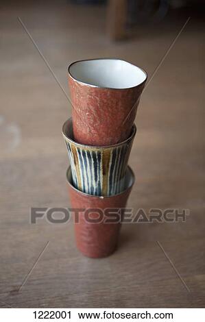 Three stacked cups on a wooden floor View Large Photo Image Stock Image - Three stacked cups on a wooden floor. Fotosearch