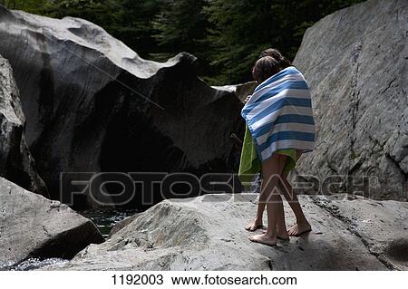Two children wrapped in towels and standing on rocks View Large Photo Image Stock Image - Two children wrapped in towels and standing on rocks. Fotosearch