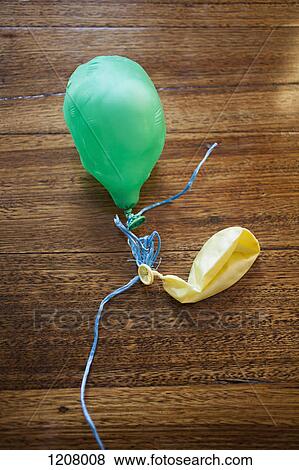 Two deflated balloons on a wooden table View Large Photo Image Stock Photo - Two deflated balloons on a wooden table. Fotosearch
