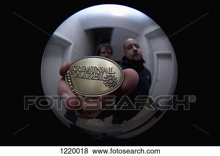 Stock Photo - Two detectives showing a crime police (German: Kriminal Polizei) badge to a peephole. Fotosearch