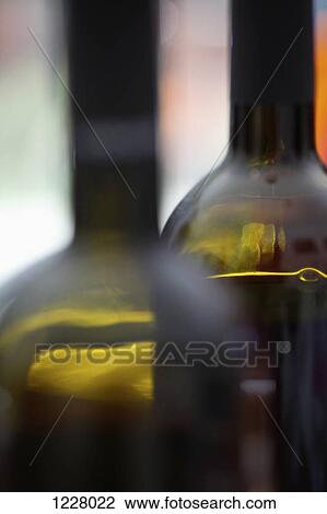 Stock Image - Two red wine bottles in a row, close-up. Fotosearch
