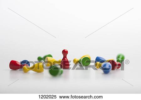 Stock Photography - Upright game piece amongst many knocked down game pieces. Fotosearch
