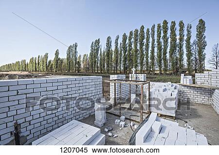 Wall and bricks at construction site with diminishing trees in the background View Large Photo Image Stock Photography - Wall and bricks at construction site with diminishing trees in the background. Fotosearch