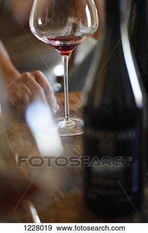 Stock Photo - Wineglasses and wine bottles on a wood table at a wine tasting. Fotosearch