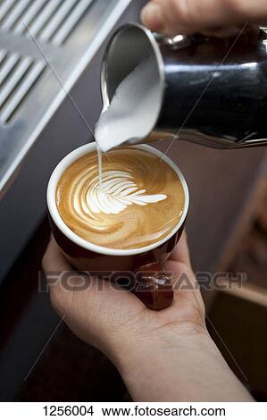 A barista decorating milk froth with a floral pattern View Large Photo Image Picture - A barista decorating milk froth with a floral pattern. Fotosearch