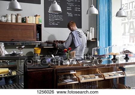A barista working at an espresso maker in a cafe, rear view View Large Photo Image Stock Photograph - A barista working at an espresso maker in a cafe, rear view. Fotosearch