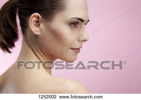 Stock Image - A beautiful young woman looking serenely to the side. Fotosearch