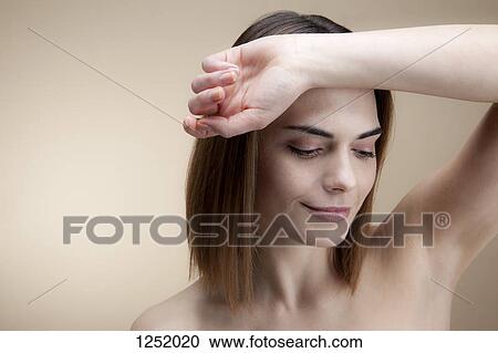 A beautiful young woman with her forearm resting on her forehead looking down serenely View Large Photo Image Stock Image - A beautiful young woman with her forearm resting on her forehead looking down serenely. Fotosearch