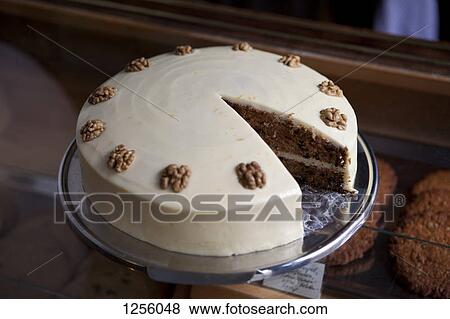 A carrot cake on a display cabinet in a cage with a piece missing View Large Photo Image Stock Photo - A carrot cake on a display cabinet in a cage with a piece missing. Fotosearch