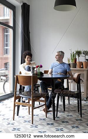 A cheerful hip mixed age couple enjoying breakfast together in their dining room View Large Photo Image Stock Image - A cheerful hip mixed age couple enjoying breakfast together in their dining room. Fotosearch