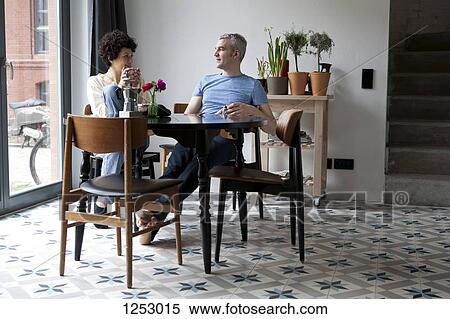 A cheerful hip mixed age couple enjoying breakfast together in their dining room View Large Photo Image Stock Photography - A cheerful hip mixed age couple enjoying breakfast together in their dining room. Fotosearch