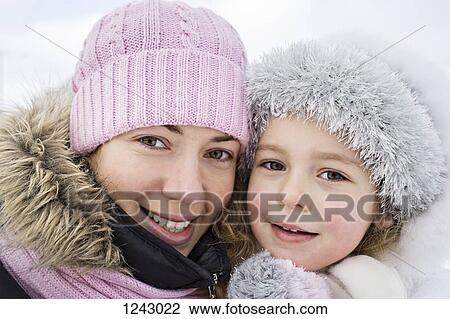 A cheerful mother and daughter in warm clothing outdoors in winter View Large Photo Image Stock Image - A cheerful mother and daughter in warm clothing outdoors in winter. Fotosearch