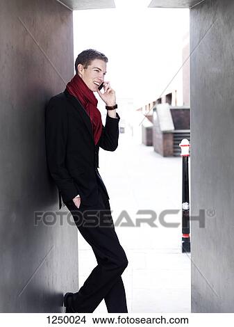 A cheerful young businessman receiving good news via his smart phone View Large Photo Image Picture - A cheerful young businessman receiving good news via his smart phone. Fotosearch