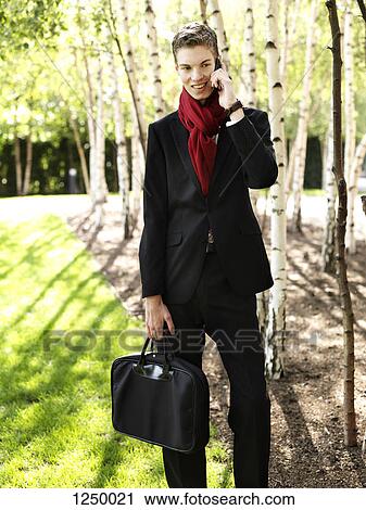 A cheerful young businessman receiving good news via his smart phone View Large Photo Image Stock Image - A cheerful young businessman receiving good news via his smart phone. Fotosearch