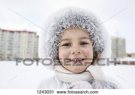 A cheerful young girl wearing warm clothing outdoors in winter View Large Photo Image Stock Image - A cheerful young girl wearing warm clothing outdoors in winter. Fotosearch