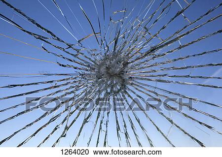 Stock Image - A clear blue sky seen through a shattered glass window. Fotosearch