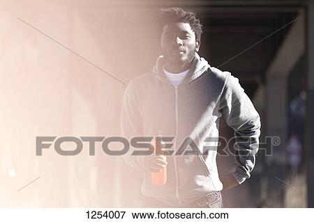 A hip young man in sports gear holding a sport drink View Large Photo Image Stock Photo - A hip young man in sports gear holding a sport drink. Fotosearch