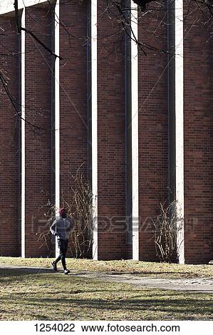 A man jogging along a sidewalk in the city during springtime View Large Photo Image Stock Image - A man jogging along a sidewalk in the city during springtime. Fotosearch