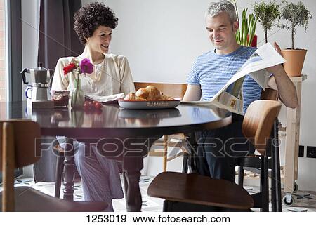 A man sharing something funny he read in the newspaper with his girlfriend View Large Photo Image Stock Photo - A man sharing something funny he read in the newspaper with his girlfriend. Fotosearch