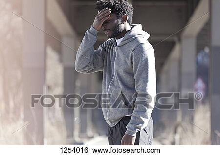 A man with his hand on his forehead with a look of dejection View Large Photo Image Stock Photograph - A man with his hand on his forehead with a look of dejection. Fotosearch