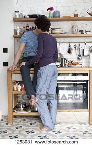 A mixed age couple kissing in their kitchen View Large Photo Image Stock Image - A mixed age couple kissing in their kitchen. Fotosearch