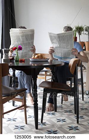 A mixed age couple reading newspapers at the breakfast table View Large Photo Image Stock Photography - A mixed age couple reading newspapers at the breakfast table. Fotosearch