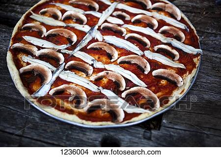 A mushroom, anchovy and tomato sauce pizza before baking View Large Photo Image Picture - A mushroom, anchovy and tomato sauce pizza before baking. Fotosearch