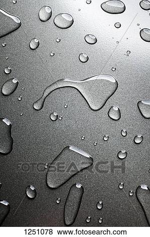 Stock Photo - A pattern of various shaped water drops on a nonstick baking sheet. Fotosearch