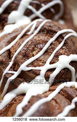 A row of cinnamon rolls with icing, full frame View Large Photo Image Stock Photo - A row of cinnamon rolls with icing, full frame. Fotosearch