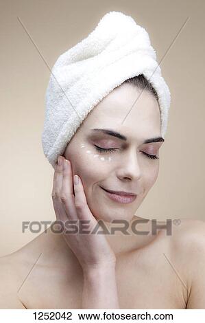 A serene woman with her eyes closed and moisturizer under one of her eyes View Large Photo Image Stock Image - A serene woman with her eyes closed and moisturizer under one of her eyes. Fotosearch