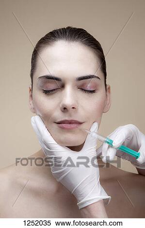 A serene young woman receiving collagen injections into her lips View Large Photo Image Stock Photography - A serene young woman receiving collagen injections into her lips. Fotosearch