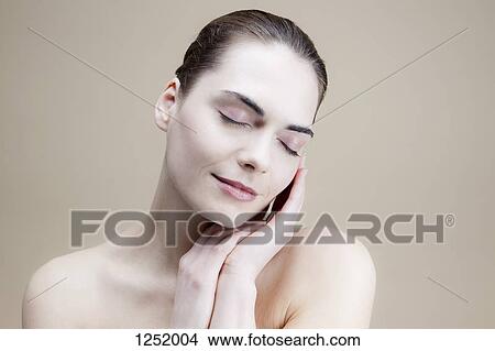 A serene young woman with her hands elegantly posed by her face View Large Photo Image Picture - A serene young woman with her hands elegantly posed by her face. Fotosearch