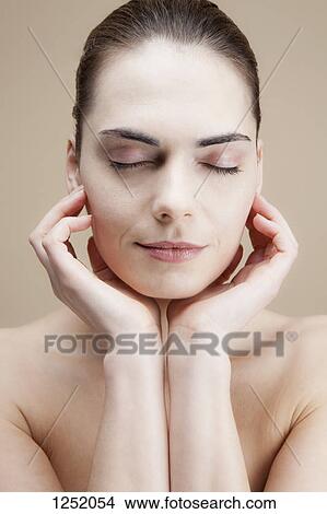 A serene young woman with her hands elegantly posed by her face View Large Photo Image Picture - A serene young woman with her hands elegantly posed by her face. Fotosearch