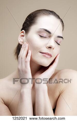 A serene young woman with her hands elegantly posed by her face View Large Photo Image Stock Image - A serene young woman with her hands elegantly posed by her face. Fotosearch