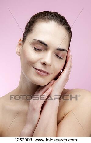 A serene young woman with her hands elegantly posed by her face View Large Photo Image Stock Photo - A serene young woman with her hands elegantly posed by her face. Fotosearch